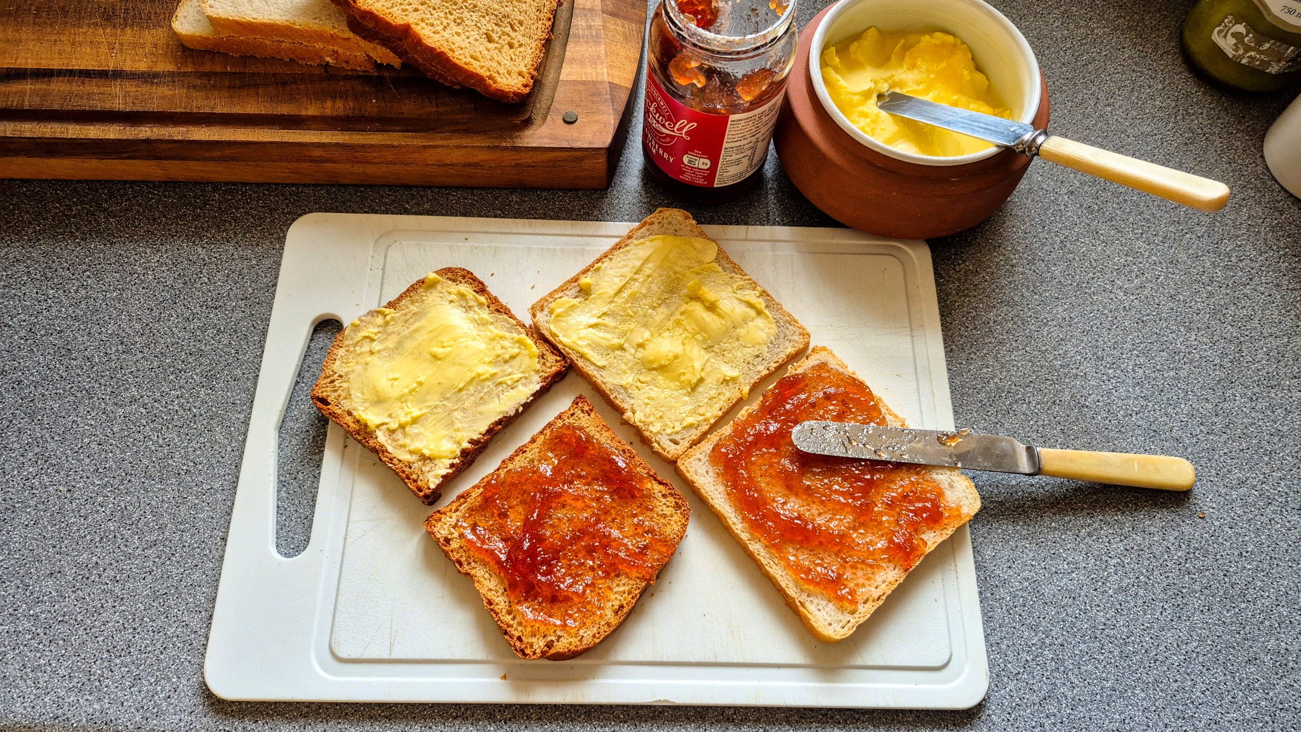 Breads spread with butter and strawberry preserves