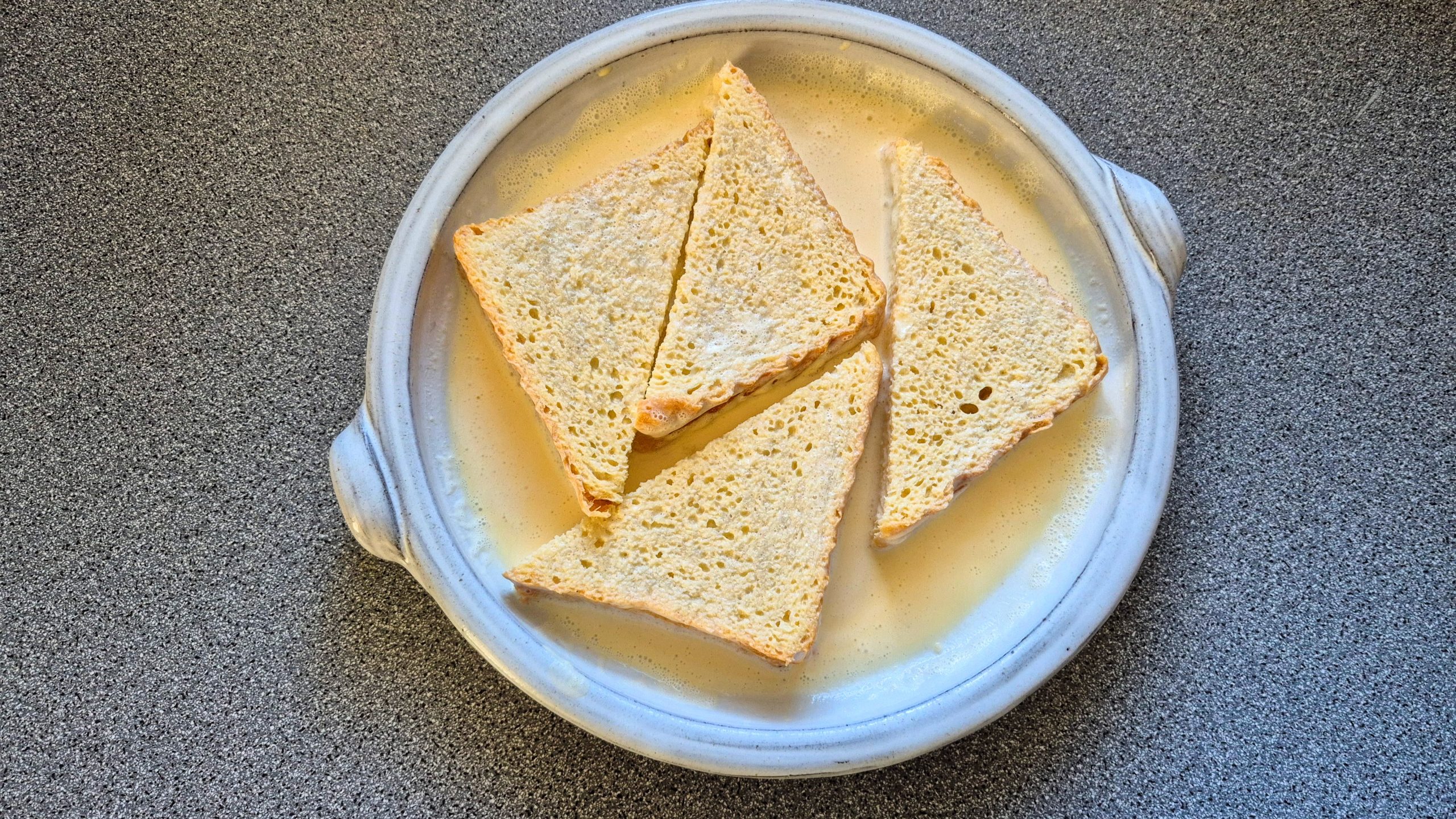 Bread slices soaking in the egg and cream mixture