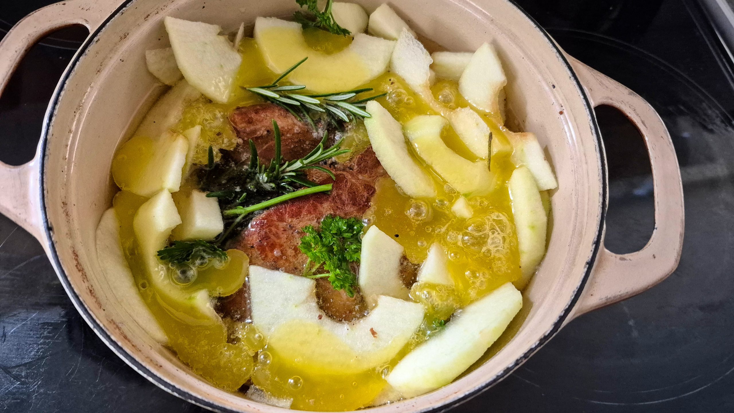 Pork with apples added and melted butter poured over